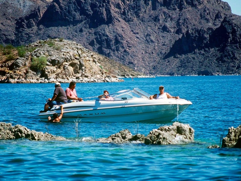 people enjoy boating on a lake in a desert landscape