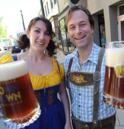 couple holding liters of beer in german attire