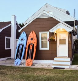 brown cottage with paddleboards leaning against it