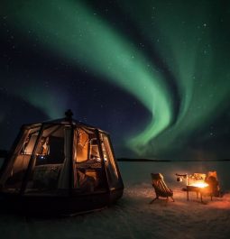 a glass igloo under the northern lights