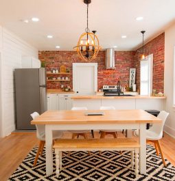dining area and kitchen with brick wall and accent lights