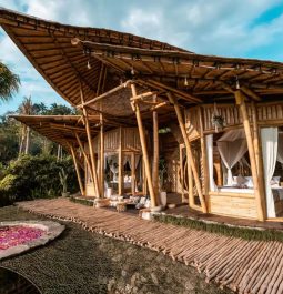 The exterior of an open-air bamboo house in Bali with an outdoor hot tub