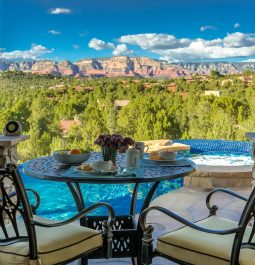 dining table overlooking a pool and red rock country