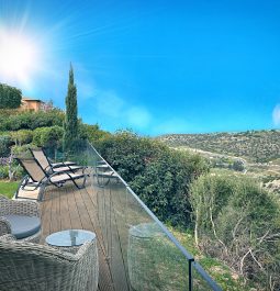 A terrace with lounge chairs overlooking the the stunning scenery of Aphrodite Hills in Cypress