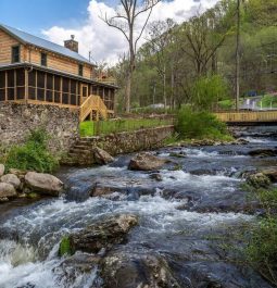 Roaring river going past wooden cabin