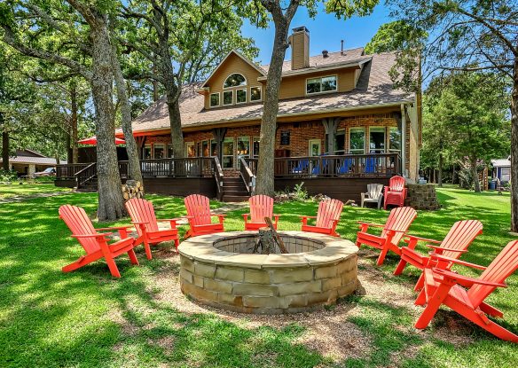 fire pit surrounded by adirondack chairs