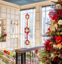 Christmas tree at top of hotel staircase with bright windows