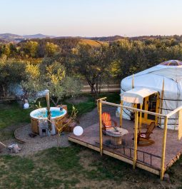 Yurt-style tent with hot tub and view of rolling hills