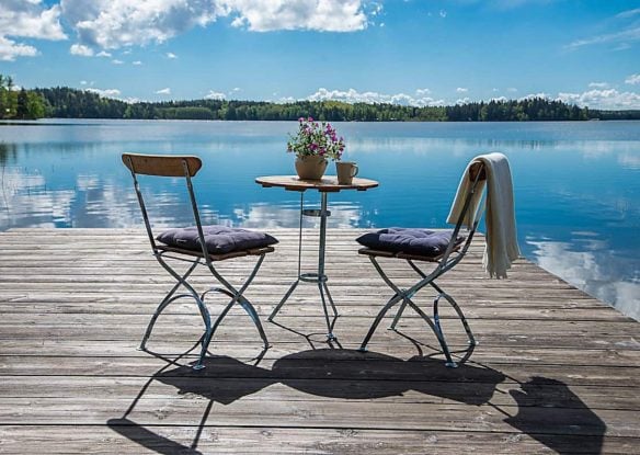 Decking with chairs set up overlooking crystal clear lake