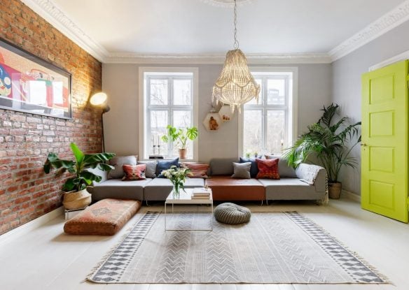 Living room with bohemian accent decor, a brick wall and a neon yellow door