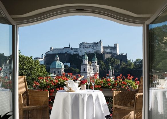 Dining table on a terrace overlooking Salzburg Fortress