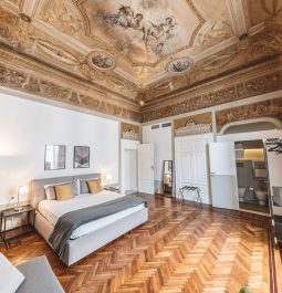 Spacious hotel room with a frescoed ceiling