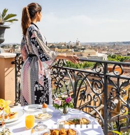 woman looking out at Rome from hotel balcony