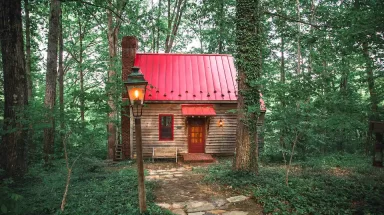 Cabin with red roof in woods