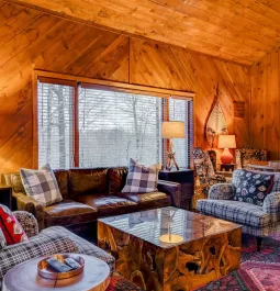 Wood-paneled living room with winter scene through the windows