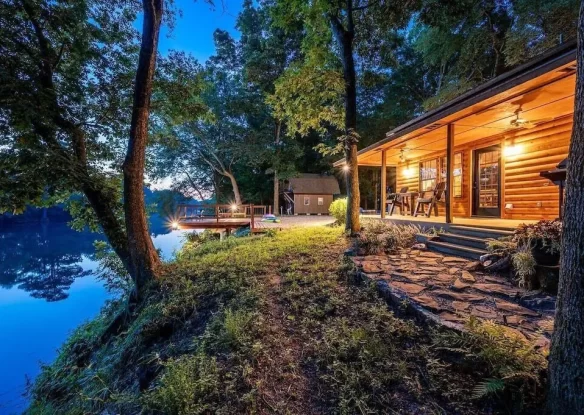 Cabin with lights on along the river