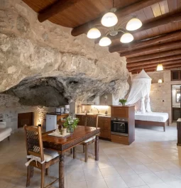 interior of cave home with table, kitchen, bed, and couch