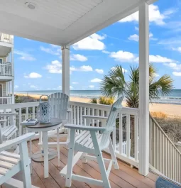 porch with chairs that looks out on the beach and ocean