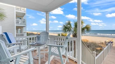 porch with chairs that looks out on the beach and ocean