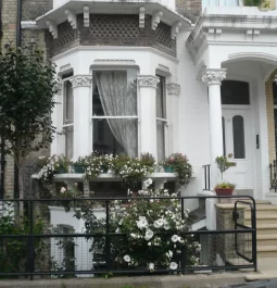 Front of London row home with fence and flowers