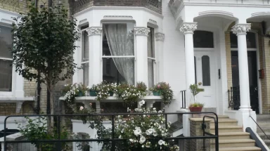 Front of London row home with fence and flowers
