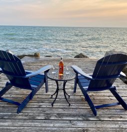 chairs on a lakefront deck at sunset