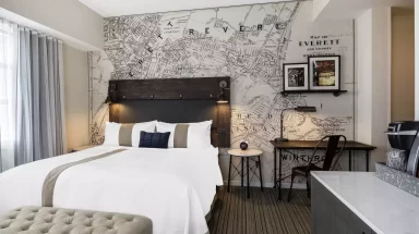 Hotel room with queen bed and map wallpaper