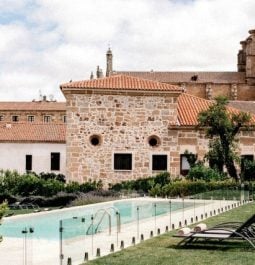 Historic overview of the hotel with grass and pool in front