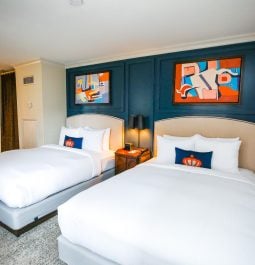 hotel room with two double beds and colorful art above the headboards
