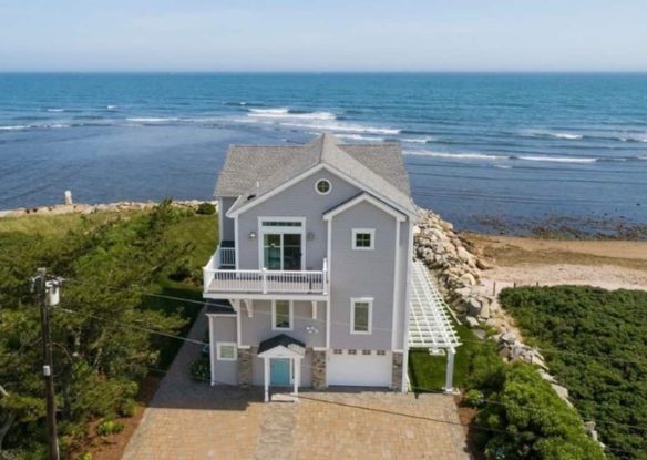 Huge grey house with sea just behind