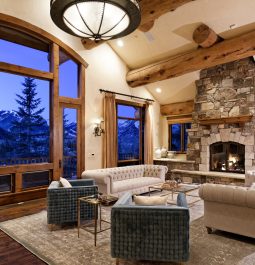 Large living room with a stone fireplace and a mountain view
