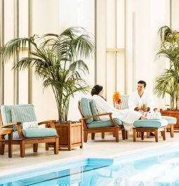 couple seated in robes at a luxury indoor pool
