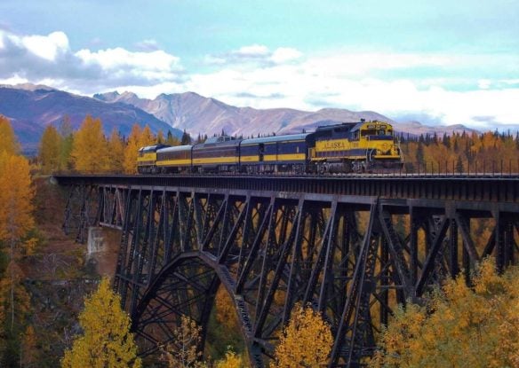 Train crossing a steel bridge in the mountains