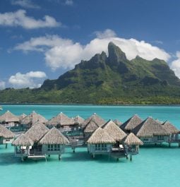 Overwater bungalows with backdrop of mountain
