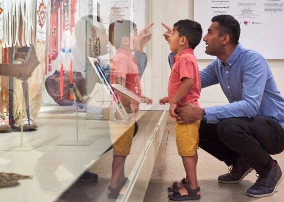 man and young child looking at exhibit in British Museum