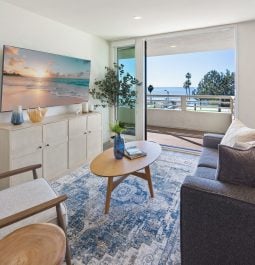 View of the living room with a balcony and an ocean vista