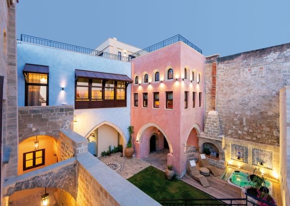 inner courtyard of stone hotel painted in pink and blue